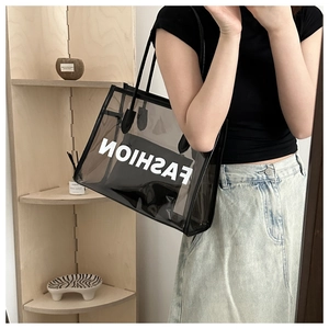 Detail of transparent black jelly tote bag with FASHION lettering and inner pouch