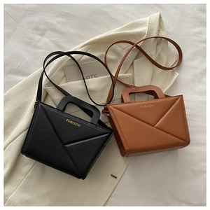 Top view of two chic folded leather handbags in black and brown with fashion logo