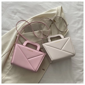 Detail of pink and cream crossbody bags with geometric 3D embossing and cutout handles