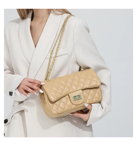 Detail of beige quilted chain bag with gold twist lock and elegant texture on faux leather