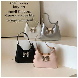 Detail view of crescent handbags in four colors with metallic bow buckles and chains