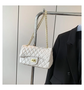 Detail of white quilted chain bag with gold twist lock and elegant metal leather strap