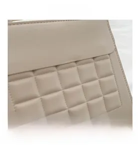 Dettaglio della trama trapuntata beige a quadri sulla borsa a tracolla in pelle