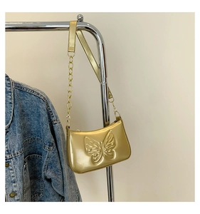 Détail du sac à bandoulière doré métallisé avec relief papillon 3D et chaîne