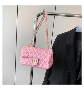 Detailed close-up of pink quilted crossbody bag with gold turn-lock and chain strap