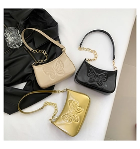 Détail de sacs sous le bras en cuir verni avec des motifs de papillons gaufrés élégants