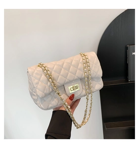 Detail showing beige quilted crossbody bag with gold turn-lock and chain strap detail