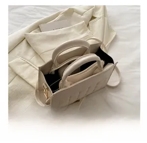 Vista interna della borsa in pelle PU beige che mostra la capienza per telefono e accessori