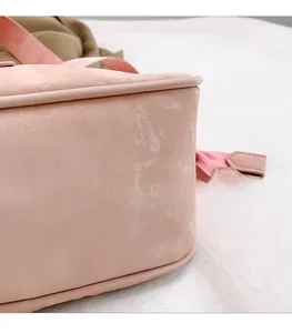 Detail of pink shoulder bag showing stitching craftsmanship and textured canvas fabric