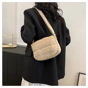 Vue arrière d'un sac bandoulière matelassé beige montrant le rembourrage et la bandoulière