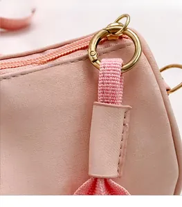 Detailed macro view of smooth metal zipper and gold hardware on pink leather handbag