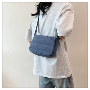 Gros plan sur le sac à bandoulière matelassé bleu avec texture en nylon souple