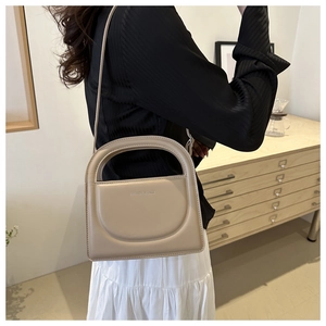 Close-up of a beige faux leather square crossbody bag with Fashion & Bags logo lettering