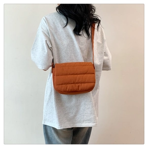Vue détaillée du sac bandoulière matelassé caramel en tissu doux avec rabat de fermeture