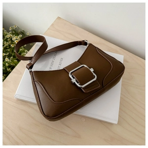 Detail view of the vintage brown underarm bag featuring a large silver square buckle
