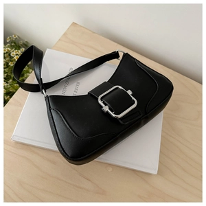 Close-up of black leather underarm bag featuring a metallic silver square buckle detail