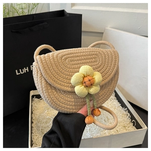Detailed view of woven saddle bag featuring a large 3D fabric flower and cotton rope texture