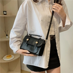 Borsa a tracolla quadrata in pelle nera stile British con fibbie dorate su modella