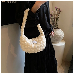 Detailed macro view of white bubble texture fabric with Love Fashion label on hobo bag