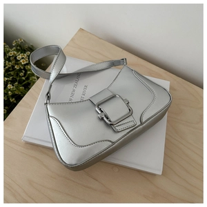 Detail of silver metallic baguette bag with square metal buckle on minimalist background