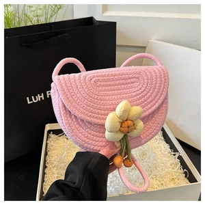Detail of pink hand-woven crochet bag featuring a large yellow sunflower decorative flower