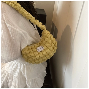 Detail view of bright yellow popcorn texture shoulder bag with Love Fashion tag