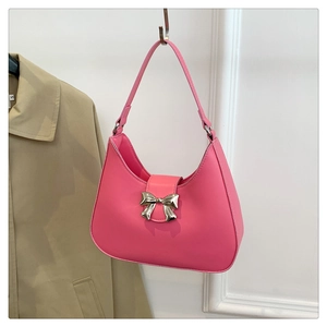 Close-up of pink crescent handbag featuring a stylish silver bow metal buckle detail