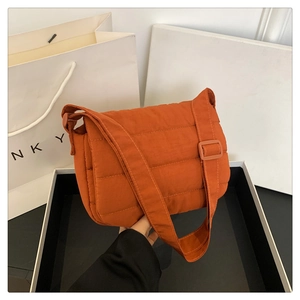 Détail du sac matelassé orange avec rembourrage doux et large bandoulière réglable