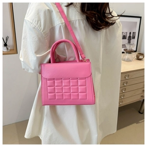 Dettaglio della trama a scacchi rosa e del manico su questa borsa a tracolla chic