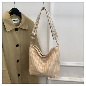Detailed view of woven straw tote texture with stylish geometric pattern shoulder strap