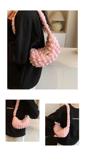 Detail showing pink bubble textured fabric and the LOVE FASHION label on a crescent bag