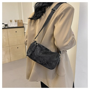 Detail of vintage black crossbody bag with marble texture and adjustable shoulder strap
