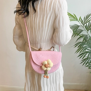Pink woven flower crossbody bag for women shown on a model with a white summer dress