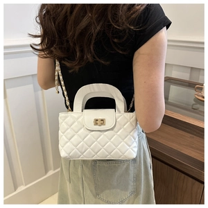 Lifestyle shot of white quilted crossbody bag with metal chain strap and turn-lock