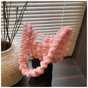 Detailed view of pink bubble textured shoulder bag featuring a Love Fashion woven label