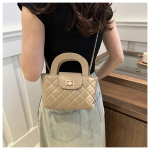 Model view of champagne quilted crossbody bag with gold chain strap and turn-lock