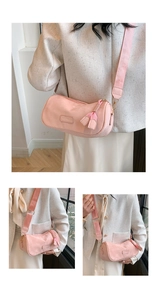 Detail of pink cylindrical pillow bag with woven strap and tassel charm decoration