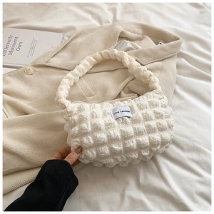 Detail of white bubble texture cloud bag featuring a LOVE FASHION woven label on it
