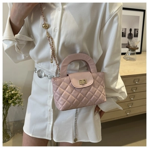 Detail of light pink quilted mini bag with gold twist lock and metal chain strap