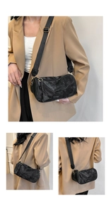 Detail view of black washed leather crossbody bag with wide strap and fashion logo