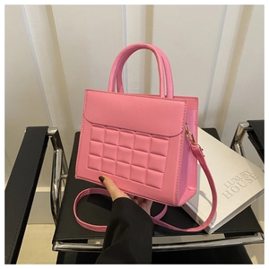 Dettaglio della borsa rosa trapuntata con fibbie metalliche dorate e trama in ecopelle