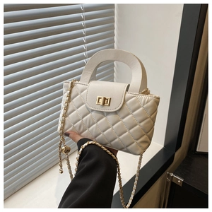 Detail of white quilted crossbody bag with gold-tone hardware and chain strap