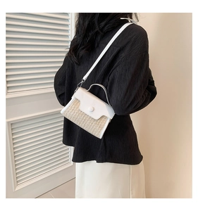 Chic beige straw and white leather crossbody bag shown on model for a stylish look