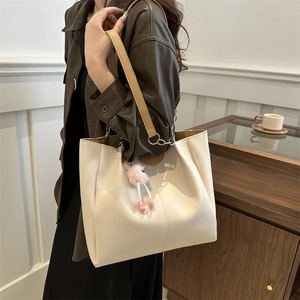Minimalist beige PU leather tote bag with brown handles and a cute decorative pendant