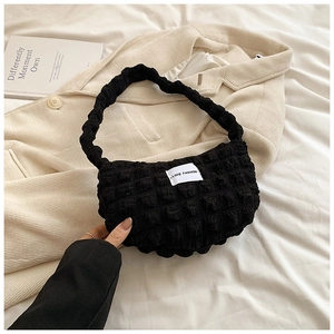 Close-up of black cloud bubble texture fabric and Love Fashion label on the shoulder bag