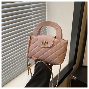 Detail of light pink quilted square handbag with gold rotating lock and chain strap