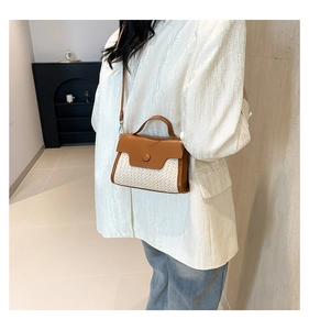Detail of a mini straw patchwork crossbody bag with brown leather and top handle