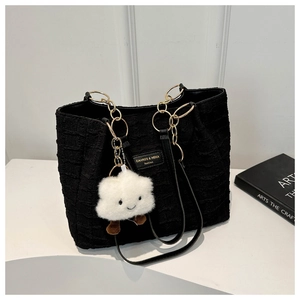 Detail of black pleated tote bag with gold chain strap and cute cloud charm