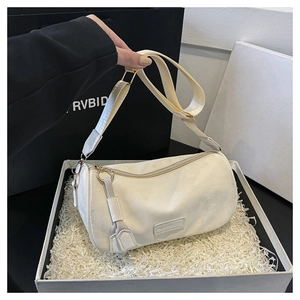 Detail of off-white cylindrical crossbody bag with wide adjustable shoulder strap