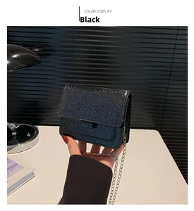 Gros plan sur un sac noir pailleté avec bandoulière chaîne pour femme